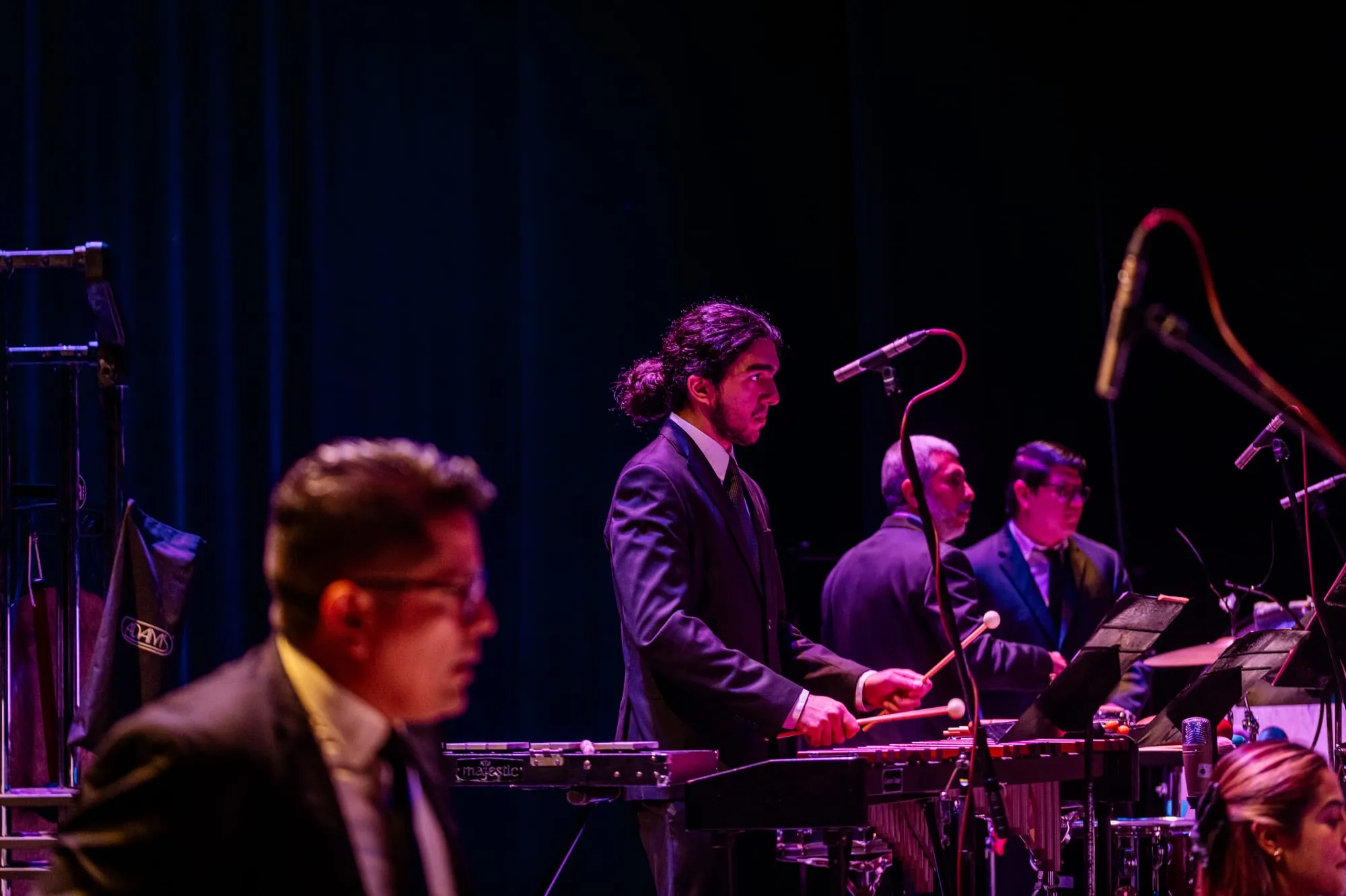 La orquesta y el solista de pie recibiendo el aplauso del público al final del concierto.
