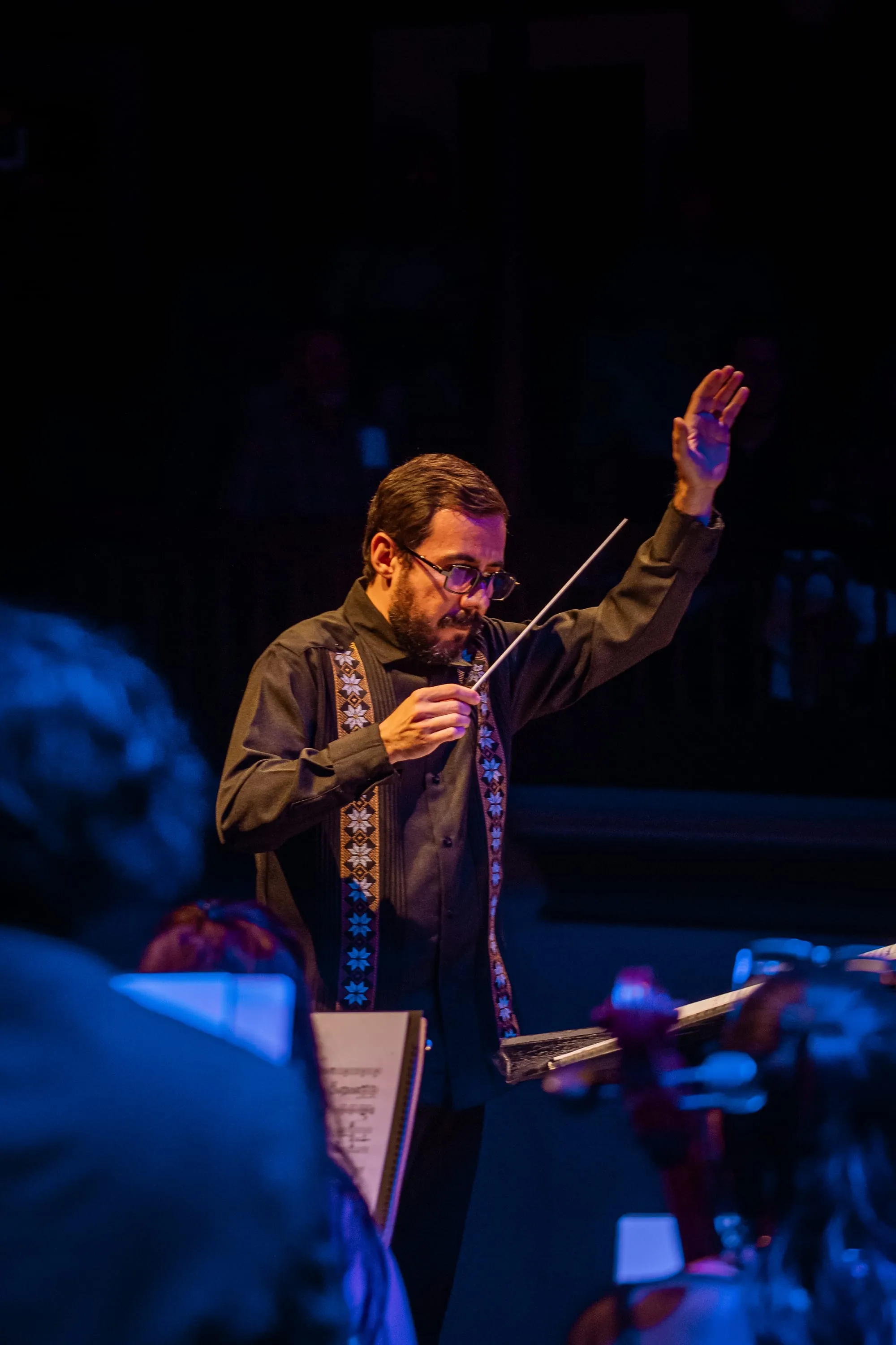 Víctor Osuna dirigiendo a la Orquesta Sinfónica del Noroeste con la batuta en alto.